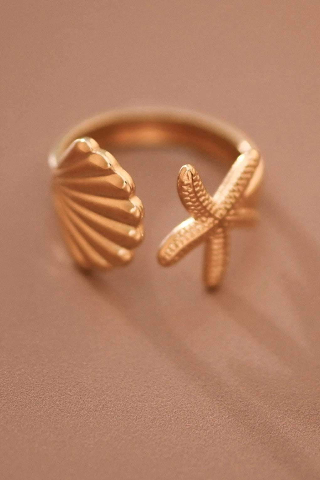 Side view of the adjustable open band gold ring featuring a starfish and shell aesthetic.