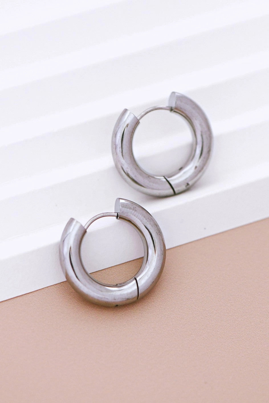 Close-up detail of the thick, hollow tube design of the Kogi Jewelry silver chunky hoops.