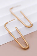 8K gold plated stainless steel classic tube hoop earrings held between fingers by Kogi Jewelry.