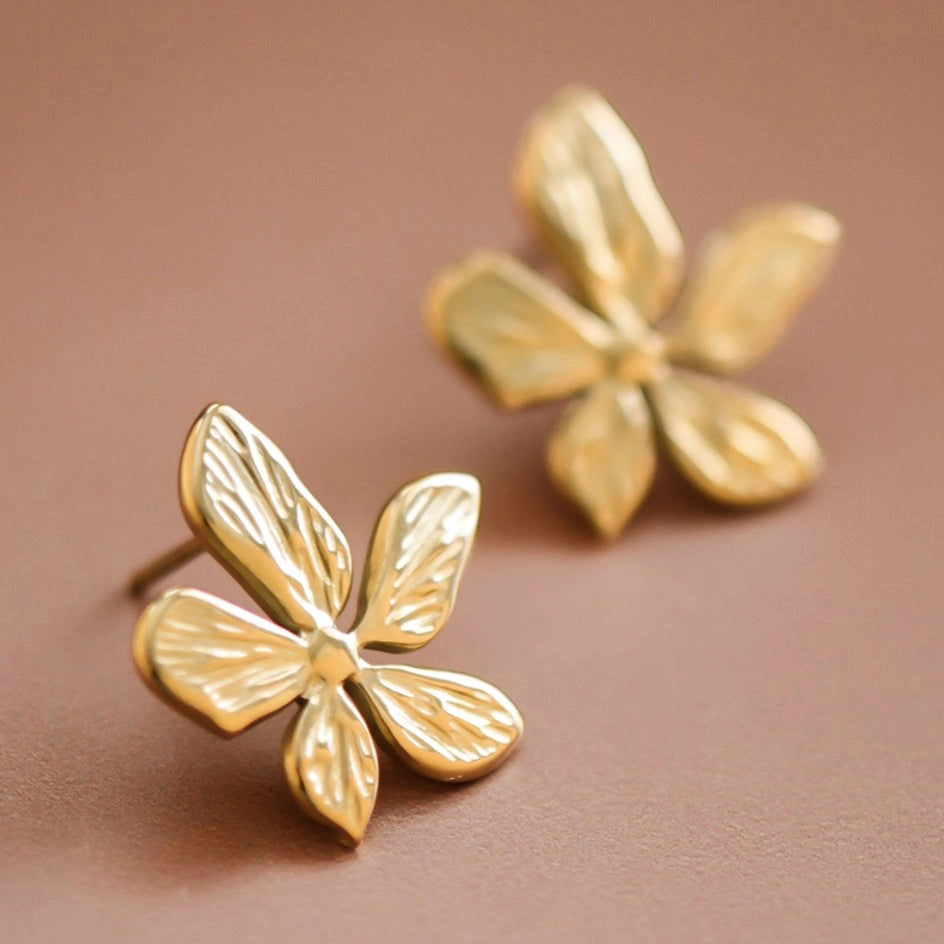 Close-up of the tarnish-free 18K gold finish on the textured flower petals of the Kogi Jewelry studs.