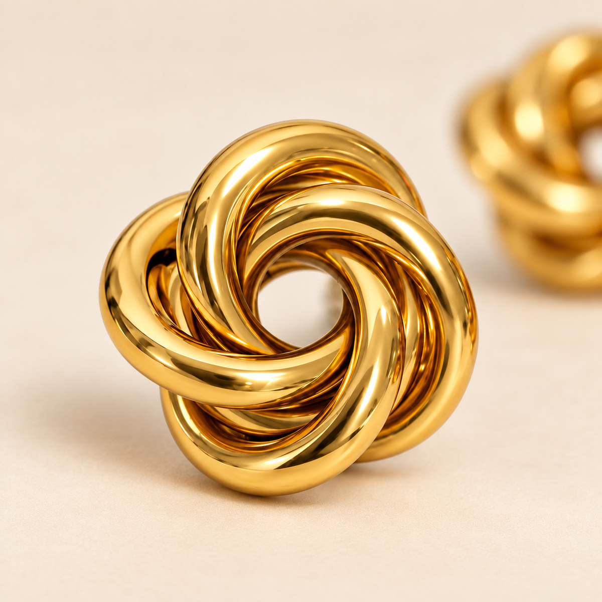 Gold knot stud earrings with polished 18K gold-plated finish