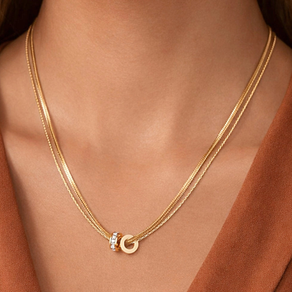 Sophisticated gold layered necklaces worn on neck, showing the mix of herringbone and classic chain textures.