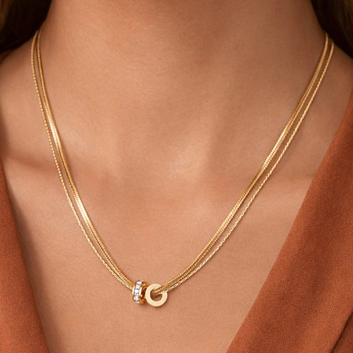 Sophisticated gold layered necklaces worn on neck, showing the mix of herringbone and classic chain textures.