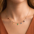 Dainty gold necklace with colorful crystals worn on neck, highlighting its vibrant and elegant sparkle.