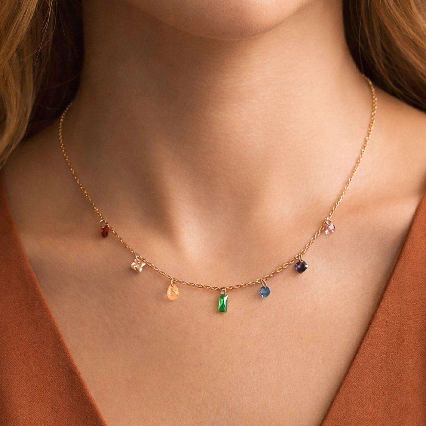 Dainty gold necklace with colorful crystals worn on neck, highlighting its vibrant and elegant sparkle.