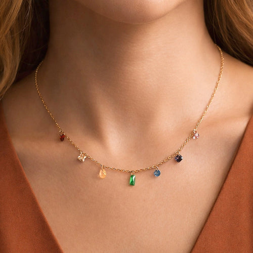 Dainty gold necklace with colorful crystals worn on neck, highlighting its vibrant and elegant sparkle.