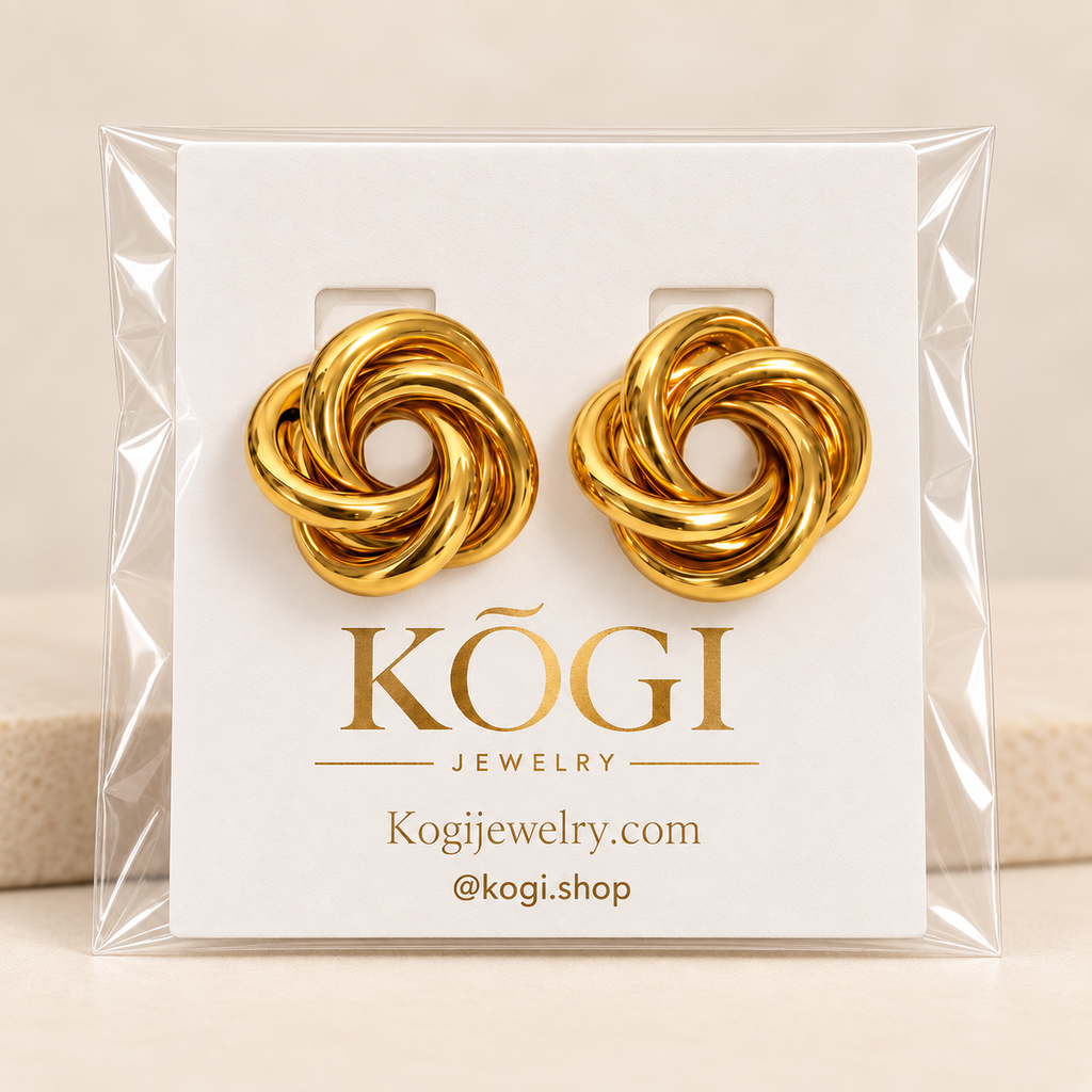 KOGI gold knot stud earrings displayed on branded jewelry packaging