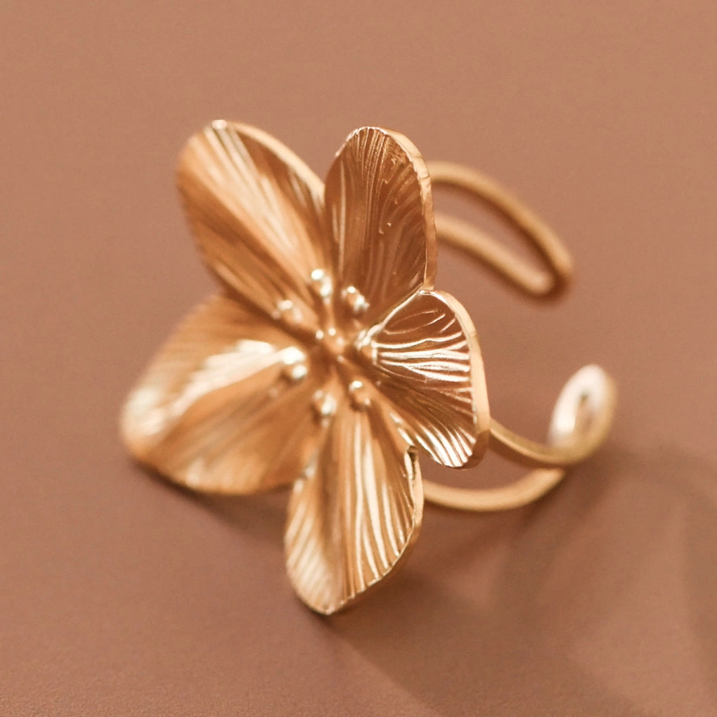 18k gold plated stainless steel adjustable flower ring on brown background by Kogi Jewelry