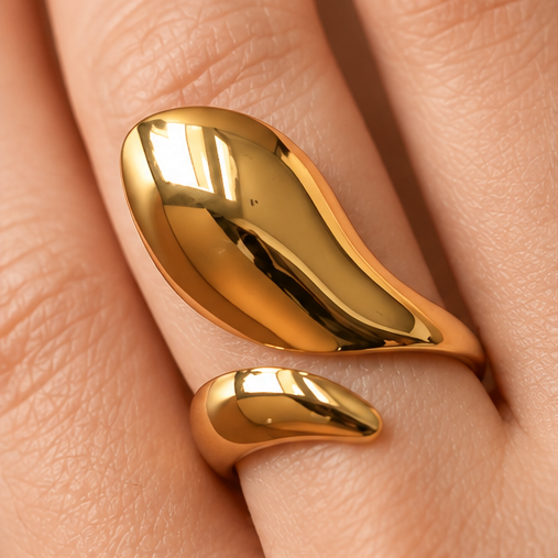 Sculptural teardrop adjustable gold ring worn on hand with polished gold finish