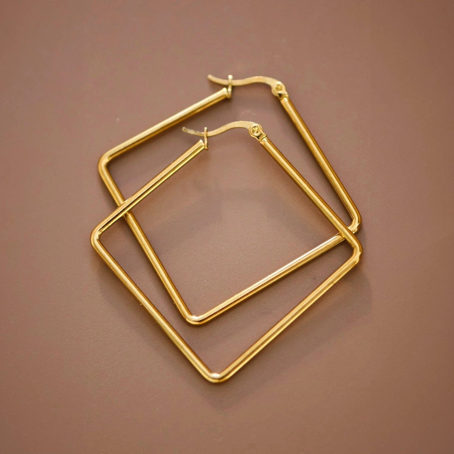 Detailed close-up of the polished surface and clean angles of the Kogi Jewelry oversized square hoops.