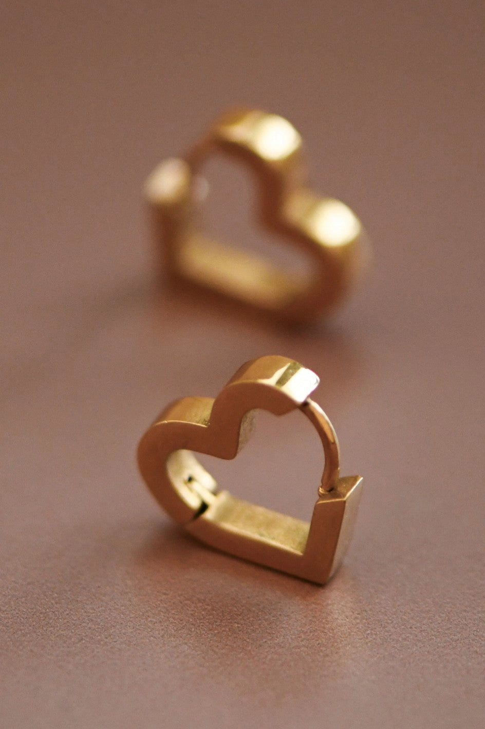 Detailed close-up of the polished surface of the Kogi Jewelry mini heart earrings.