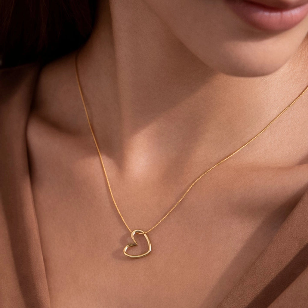 Side view of the minimalist gold heart pendant, showing its polished tarnish-resistant surface.