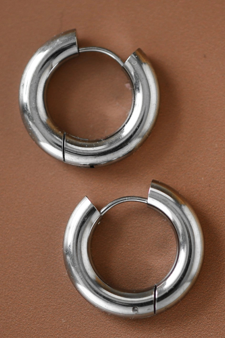 Detailed close-up of the mirror-like finish on the silver stainless steel chunky earrings.