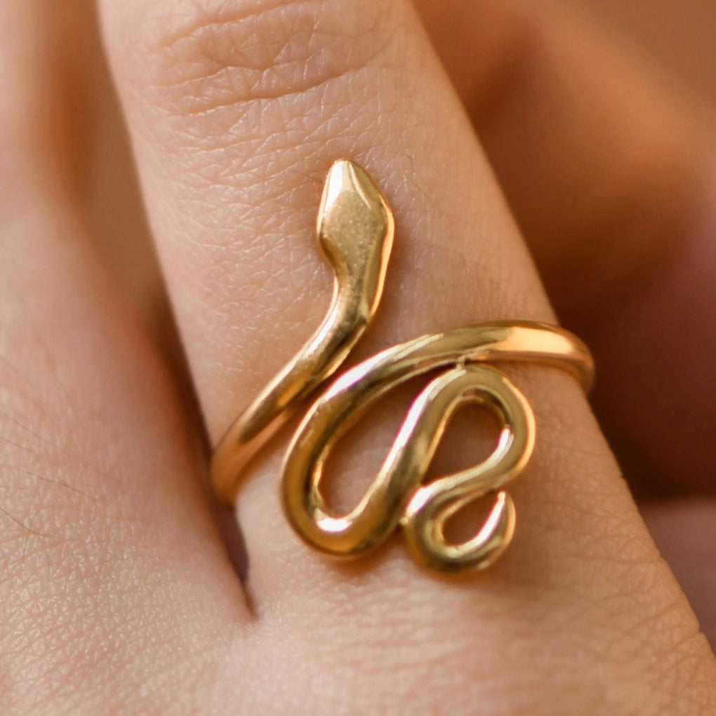 Close up of a sculptural gold snake ring showing the high-quality 18K gold finish and water-resistant texture.