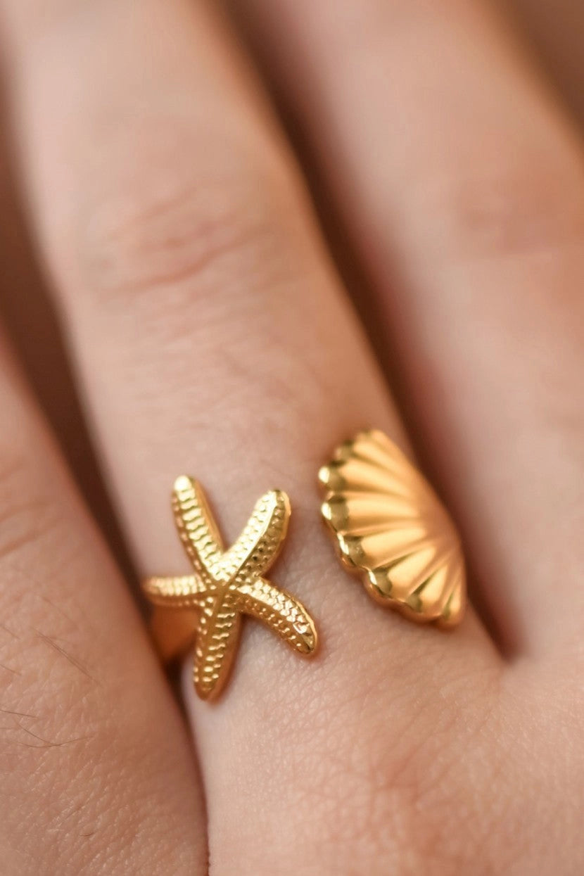 Trendy beach-style gold ring worn as a statement piece for a summer vacation look.