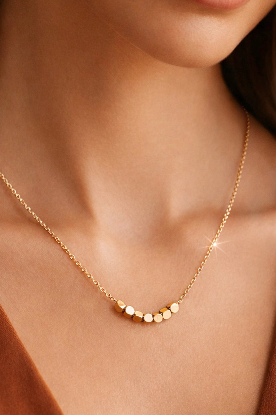 Close-up of the tarnish-free 18K gold square beads and durable link chain.