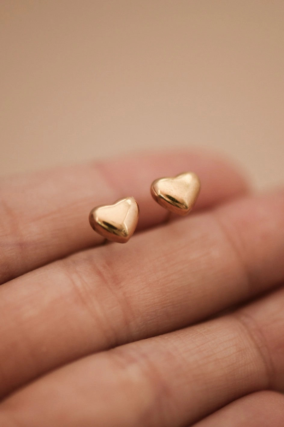 Pair of tarnish-free 18K gold plated heart-shaped post earrings in stainless steel.