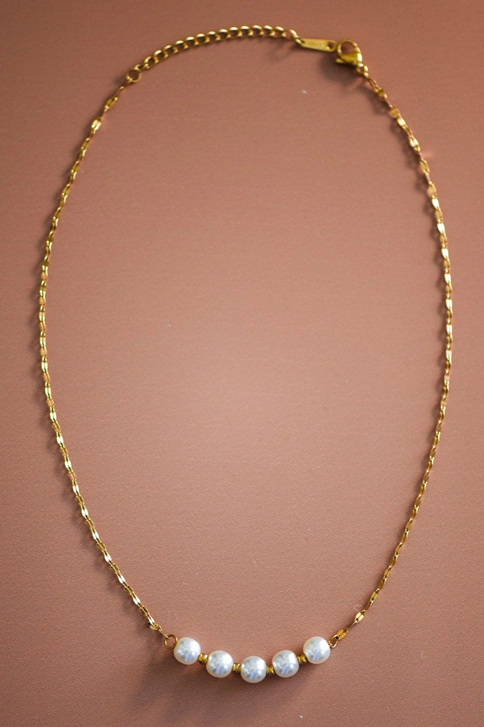 Close-up of the tarnish-free 18K gold links and elegant pearls on the Kogi Jewelry station necklace