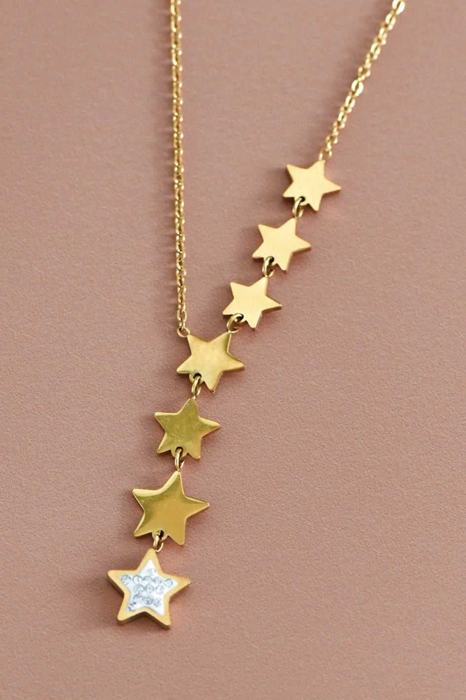 Close-up of the tarnish-free 18K gold star charms on the Kogi Jewelry lariat necklace.